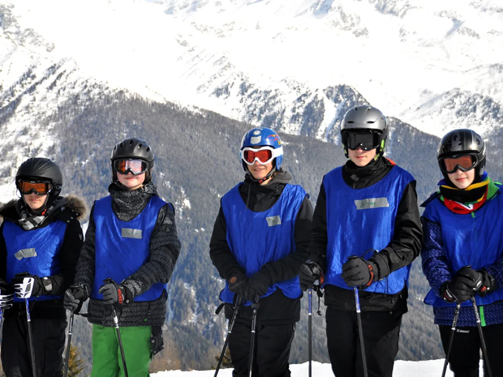 Fünf Jugendliche mit Helm und Skibrille stehen nebeneinander.